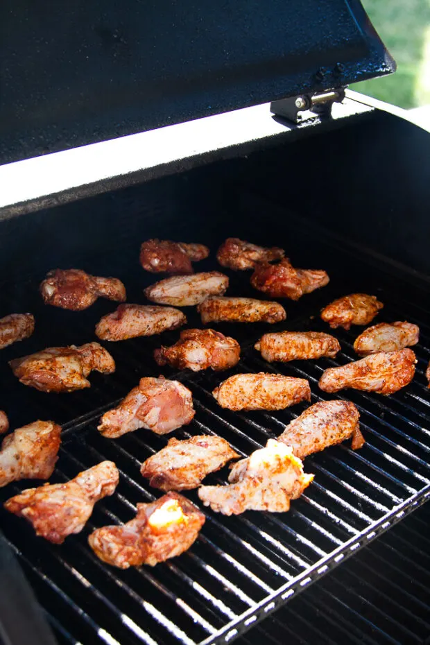 Wings on the grates of a pellet smoker.