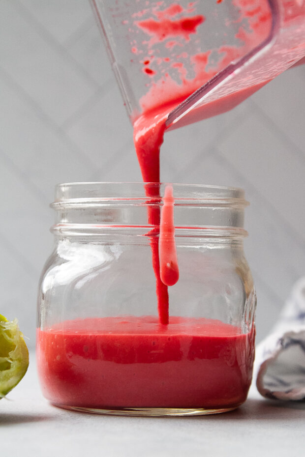 Finished vinaigrette being poured into a glass jar. 