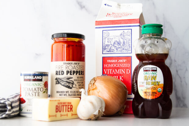 Ingredients for roasted red pepper and tomato soup: jarred roasted red peppers, tomato paste, milk, onion, garlic, honey, and butter. 