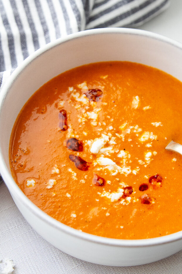 Bowl of tomato soup with goat cheese and chili crunch.