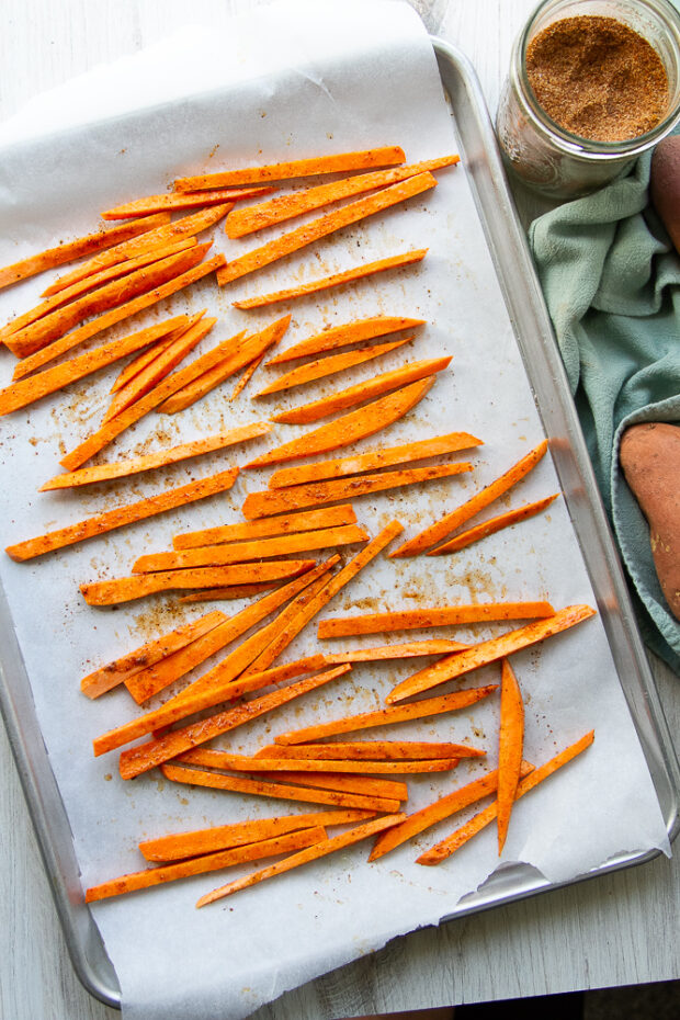 Fries spread out on the pan ready for roasting.