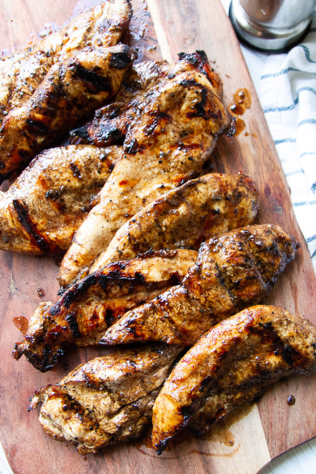 Freshly grilled and juicy balsamic grilled chicken on a cutting board.