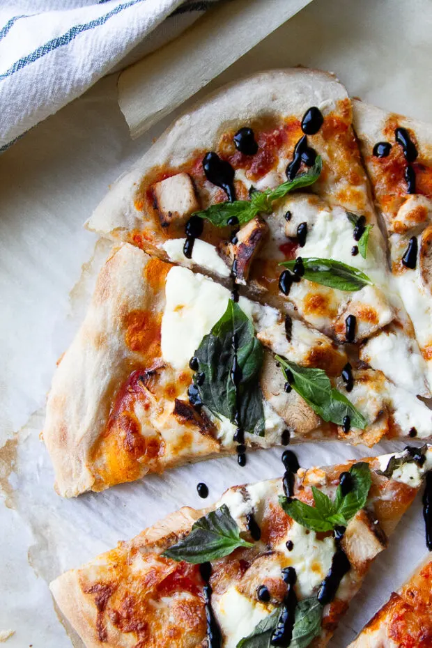 Put some grilled balsamic chicken on pizza! This photo shows a pizza with chicken, ricotta, mozzarella, fresh basil, and balsamic glaze.