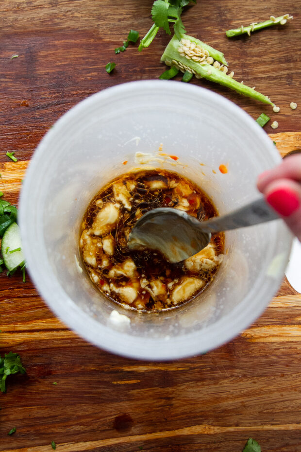 Plastic deli container with the dressing ingredients inside.