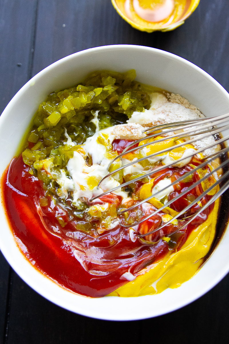 Ingredients for burger sauce in a bowl with a whisk.