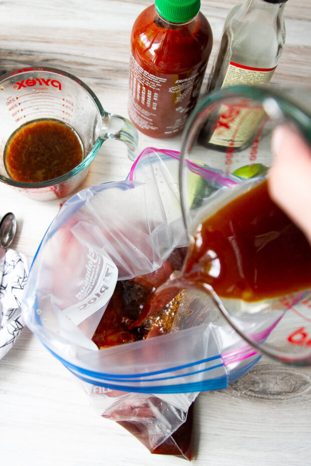 Pouring the marinade into a gallon zip top bag.