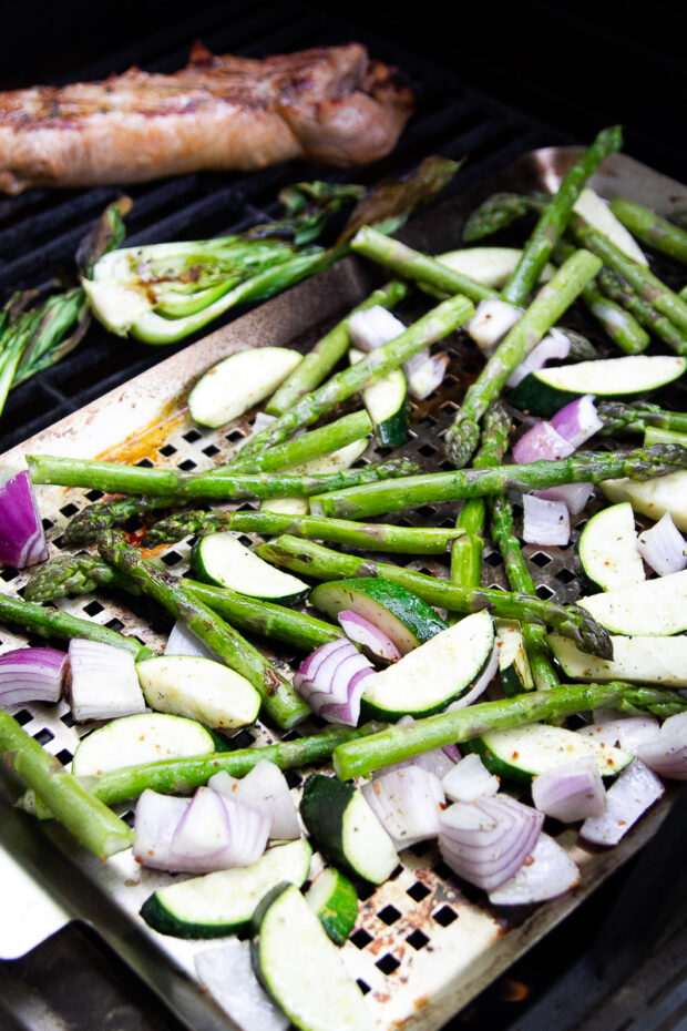 Vegetables on a grill pan next to the pork.