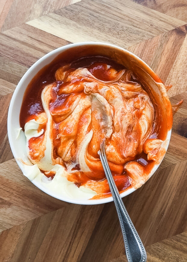 Sriracha and mayo half-mixed in a small bowl.