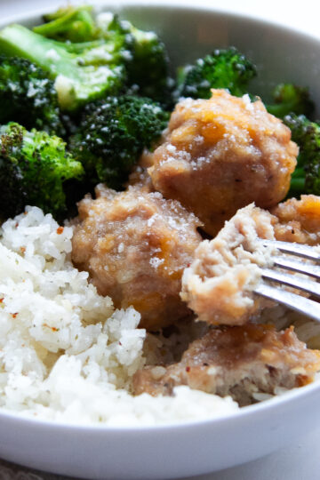 chicken meatballs in a bowl with broccoli and rice