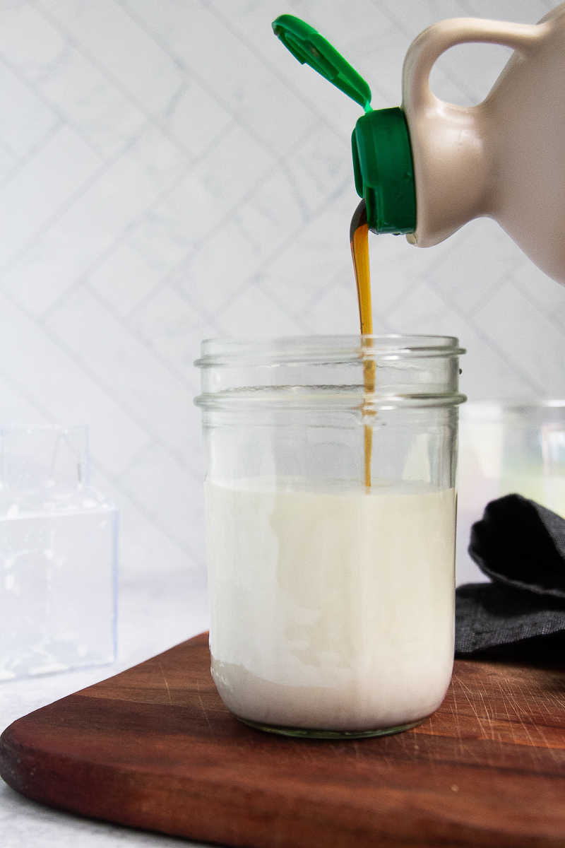 Maple syrup poured into a mason jar to sweeten the creamer.