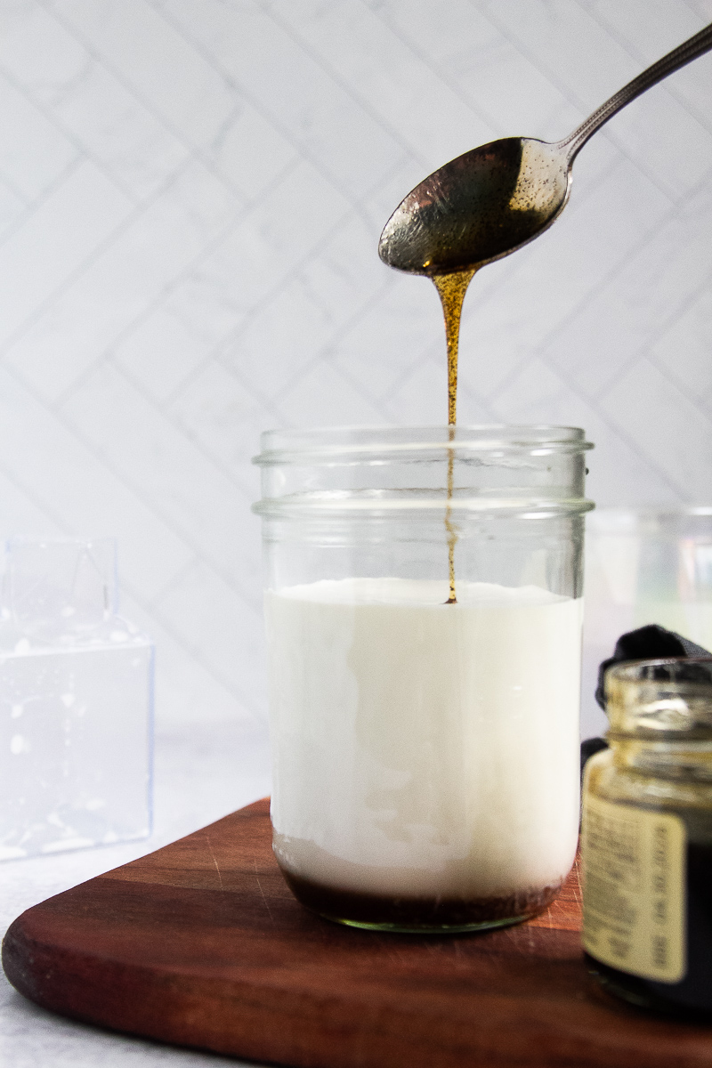 Vanilla bean paste poured into a mason jar to flavor the creamer.